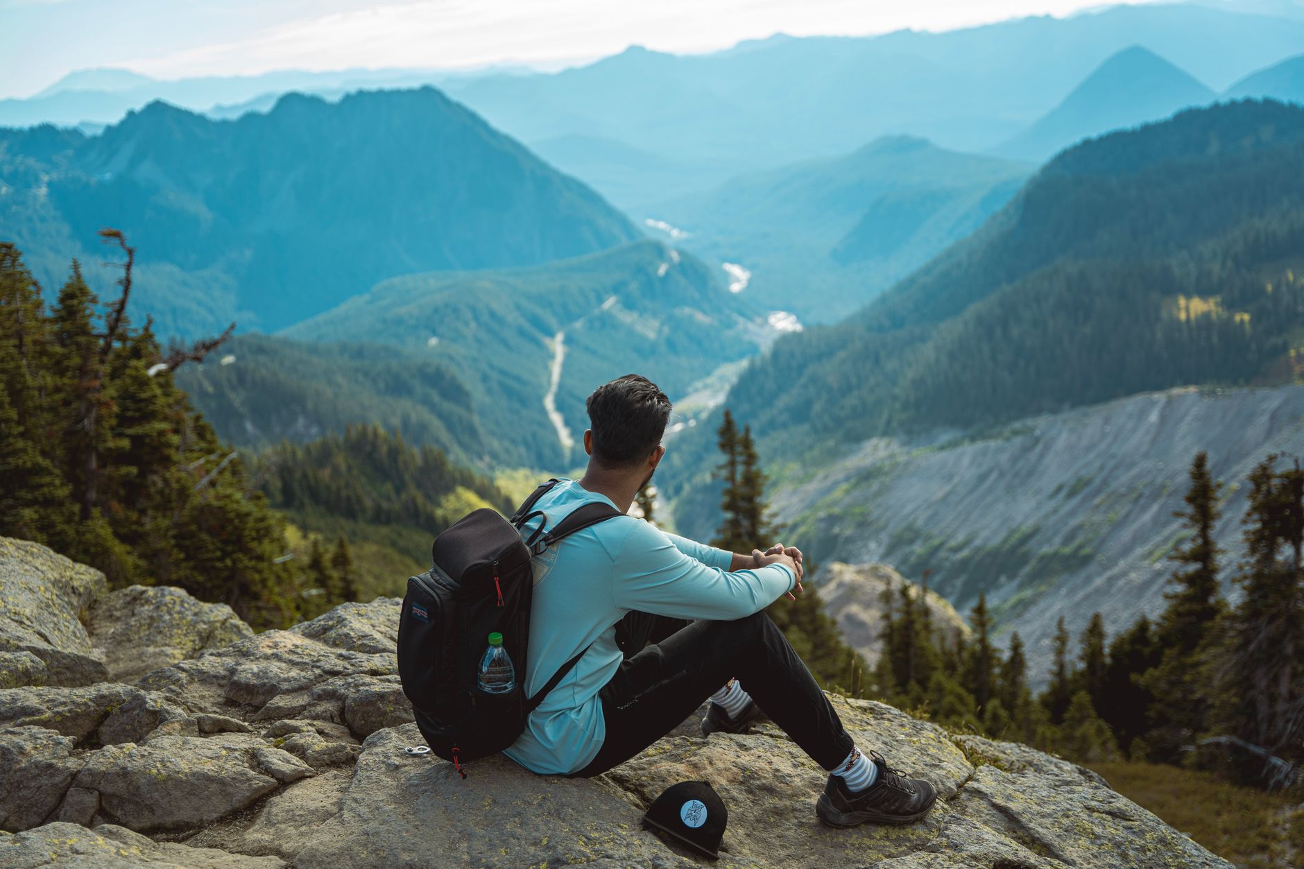 Travel journal and camera on wooden table overlooking mountains
